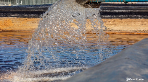 water stroomt uit leiding bij boorlocatie