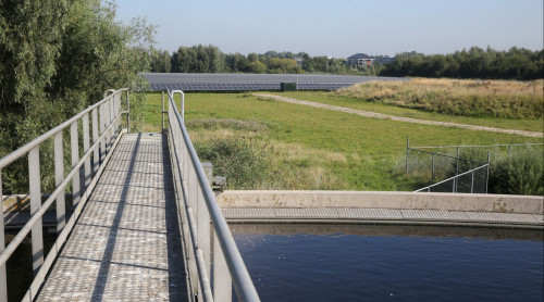 rioolwaterzuiveringsinstallatie op voorgrond en op achtergrond zonnepark