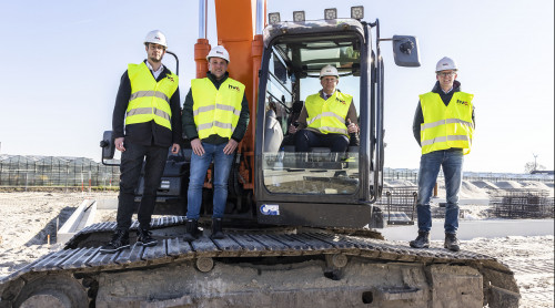 Aftrap werkzaamheden aardwarmte Maasdijk, Tarek Hopman (business ontwikkelaar HVC), Jacco Besuijen (voorzitter warmtecoöperatie Maasdijk), wethouder Pieter Varekamp (gemeente Westland) en Marco van Soerland (directeur warmte HVC) bij een rupskraan