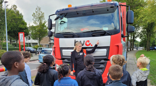 Chauffeur laat schoolkinderen de inzamelwagen zien