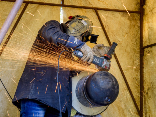 Man bewerkt een warmteleiding met een slijptol